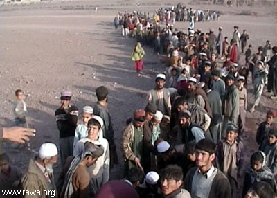 Many refugees lined up to receive drinking water from a tank