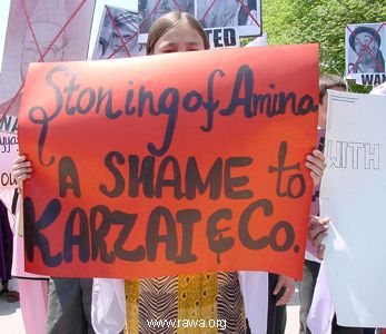 An Afghan girl carries a placard to condemn the current inhuman murdering of Amina, a 29-years old woman who was stoned to death in Afghanistan by the order of a local court.